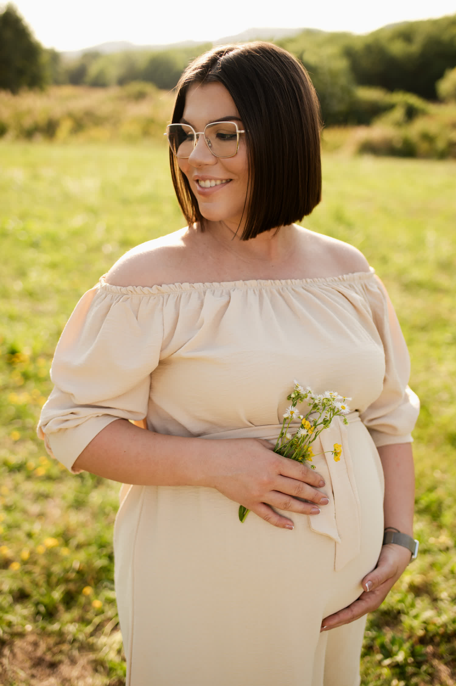 szemüveges kismama virágot tart